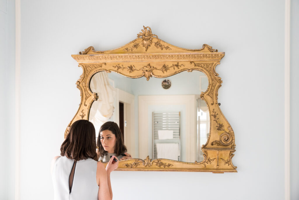 Bridesmaid getting ready in front of a mirror