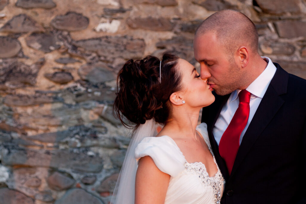 Couple Portrait kissing against beach stone wall Wedding Photographer Ottawa