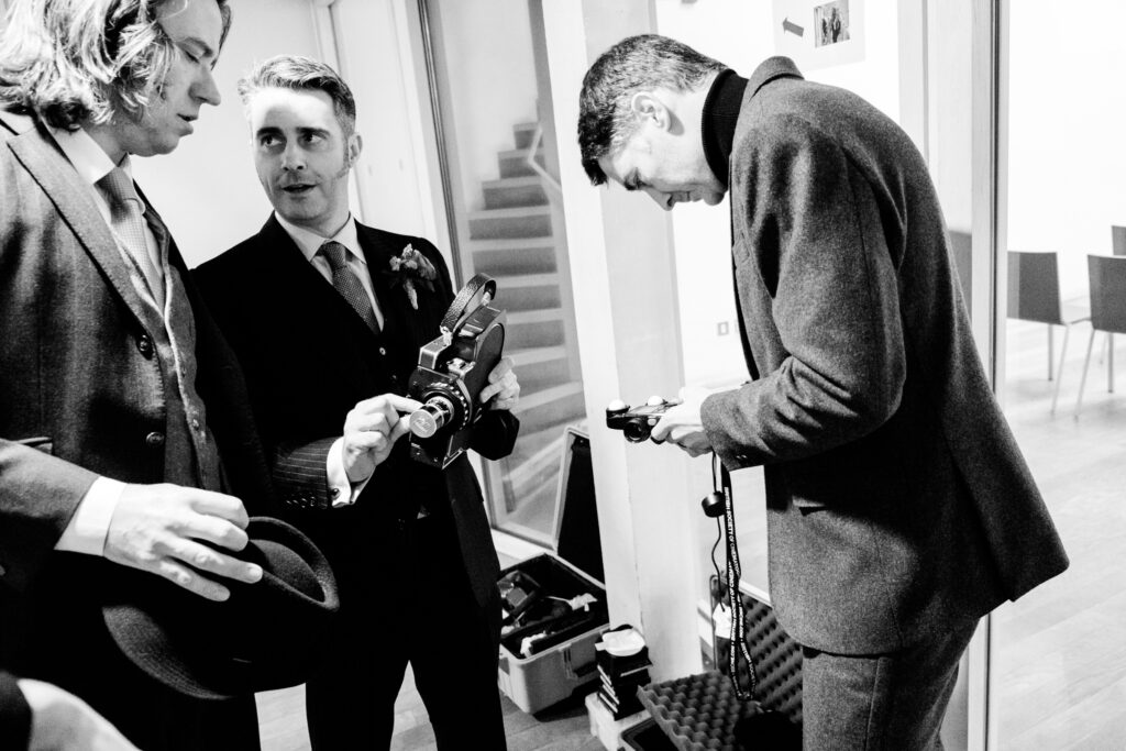 Groom holding a vintage film camera to record the wedding ceremony by Ottawa Wedding Photographer Sara