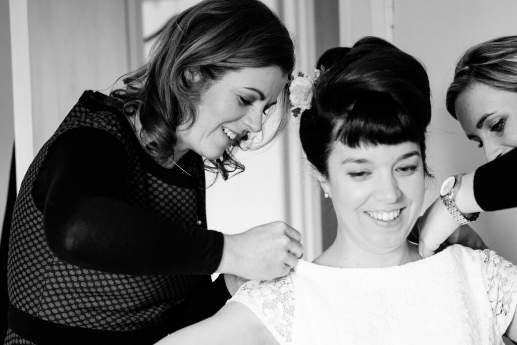 Bride putting on her dress by Ottawa Wedding Photographer Sara