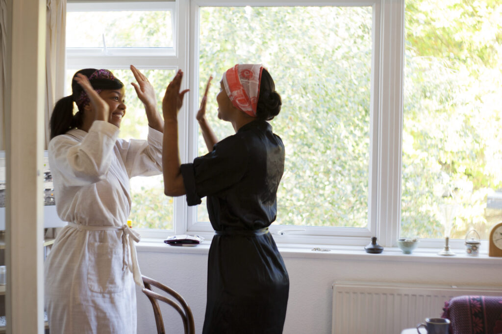 Colour photograph of a bride to be and her sister excited before the wedding
