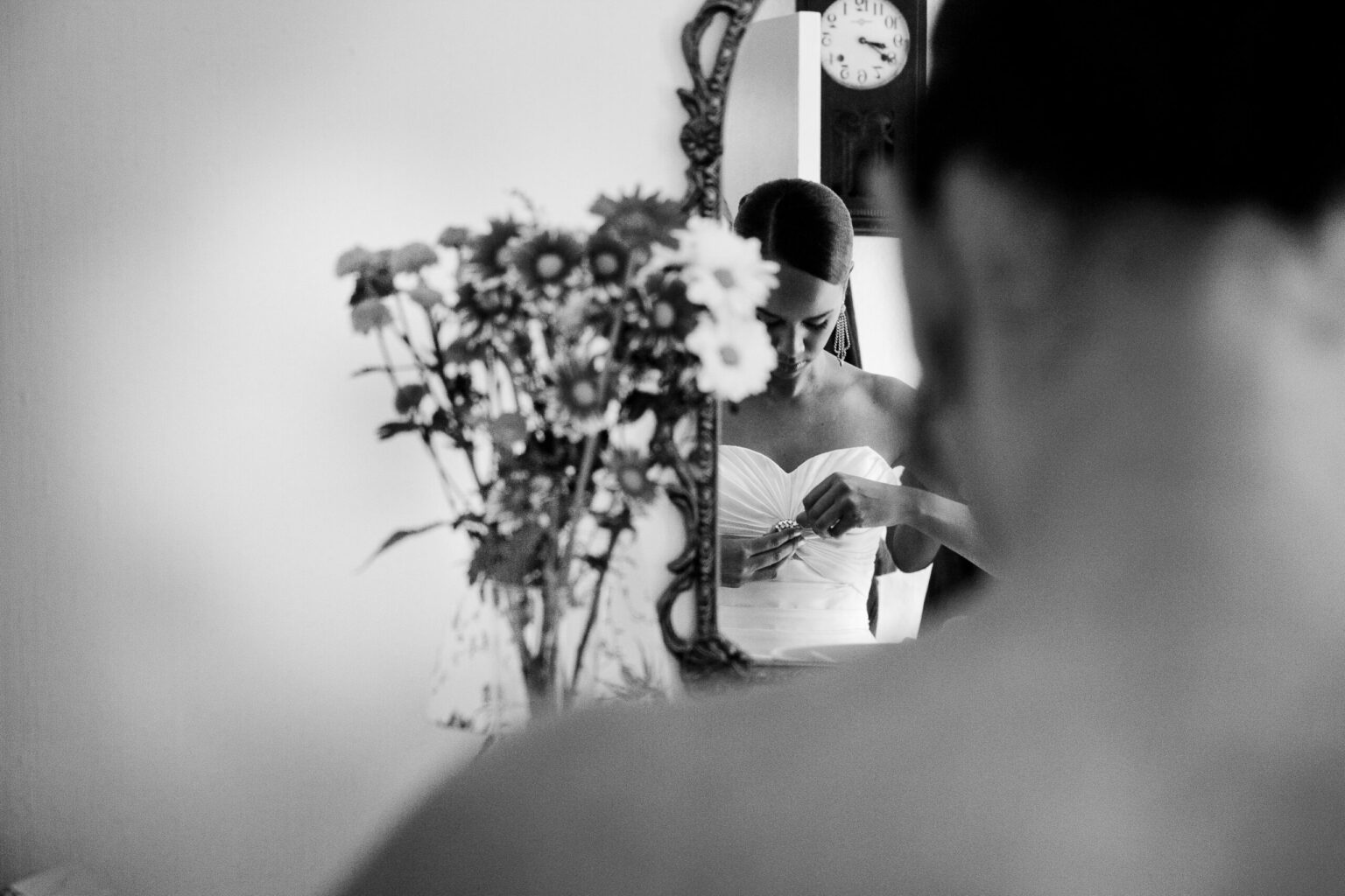 Black and white photograph of a bride looking in the mirror adjusting her dress Ottawa Photographer Wedding