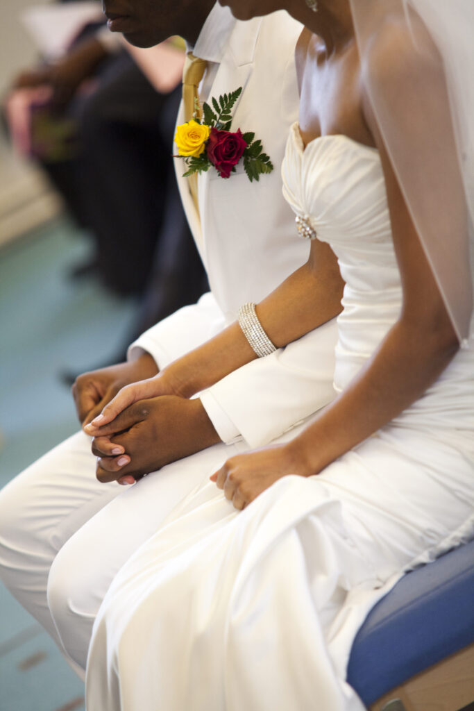 Detail of bride and groom holding hands during the wedding ceremony