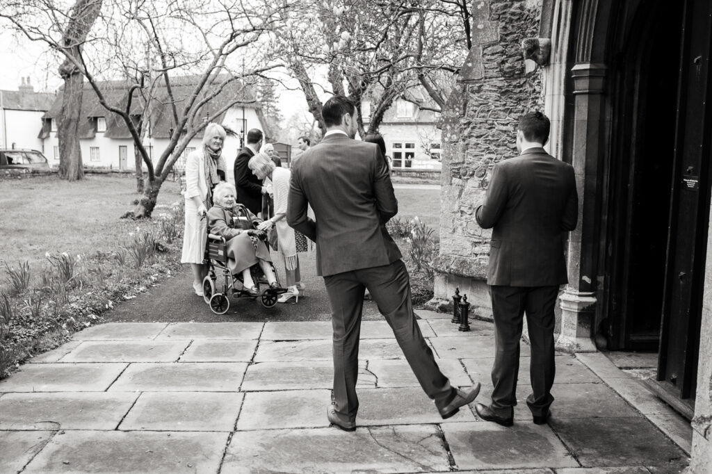 Groomsmen outside Church welcoming guests by Documentary Ottawa Wedding Photographer Sara