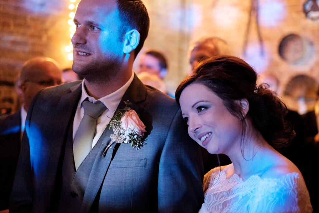 Bride and Groom watching family singing at the reception by Ottawa Wedding Photographer Sara