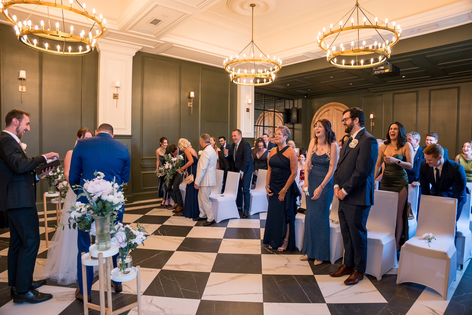 Ottawa Wedding Photographer Sara VD-4680 ❥ Ottawa Wedding Photographer Wide shot of ceremony room with Guests laughing during the ceremony by Ottawa Wedding Photographer Sara